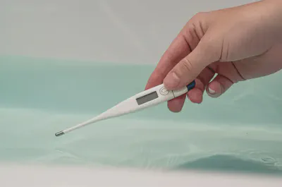 온도계로 반신욕 물 온도를 재는 손