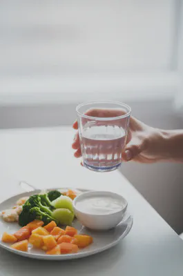 아침 식사와 함께 물을 마시는 손