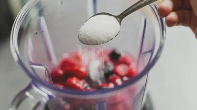 베리 스무디에 설탕을 넣는 모습