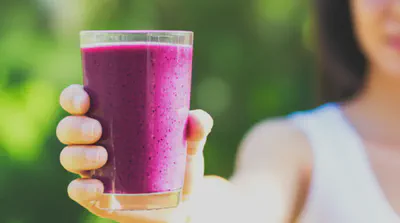 야외에서 베리 스무디를 마시는 모습