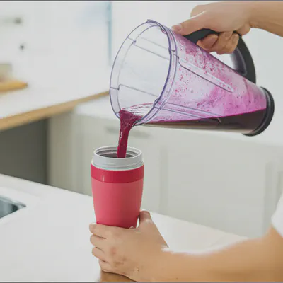 베리 스무디를 휴대용 컵에 담는 모습