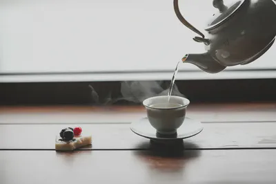 아름다운 차 세트와 함께 차를 따르는 모습. 올바른 차 섭취법을 상징합니다.