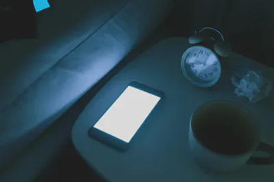 불면증의 다양한 원인을 상징하는 이미지: 스마트폰, 커피, 스트레스